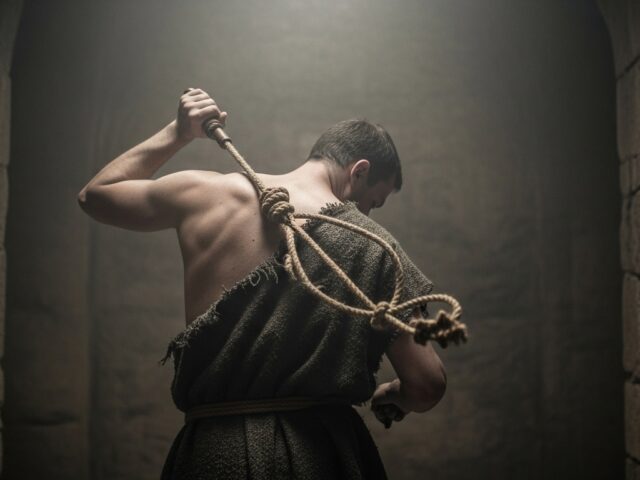 homem pagando penitência batendo em suas próprias costas com uma corda